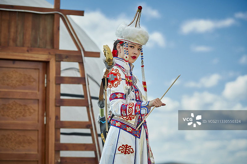 草原上蒙古包前身穿蒙族服饰身挎长弓的少女图片素材
