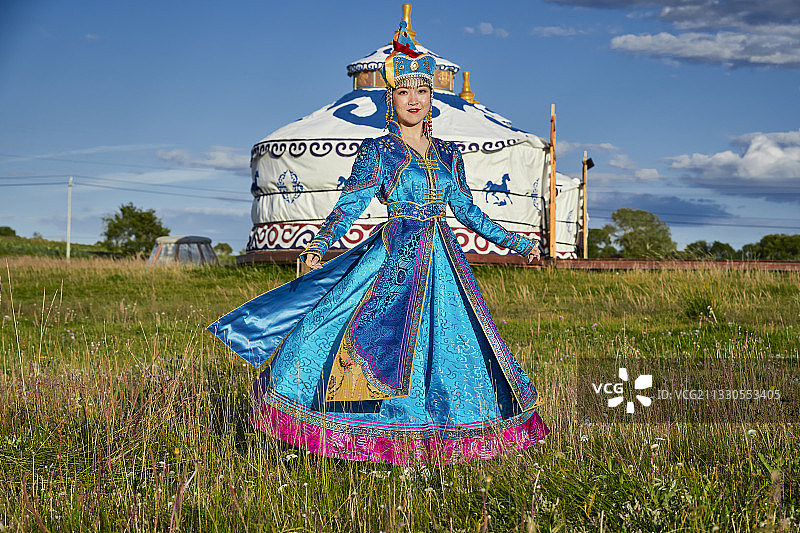 草原上蒙古包前穿着蒙古族传统服饰的少女图片素材