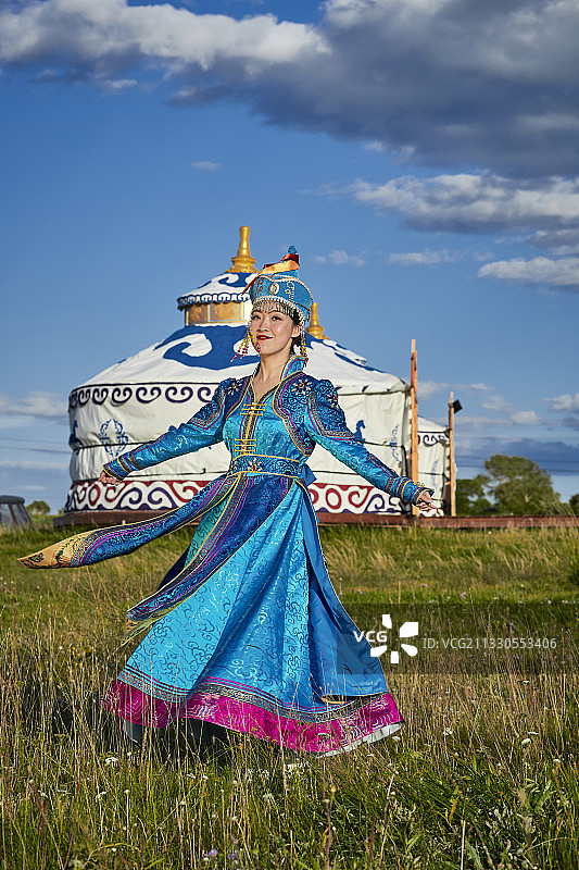 草原上蒙古包前穿着蒙古族传统服饰的少女图片素材