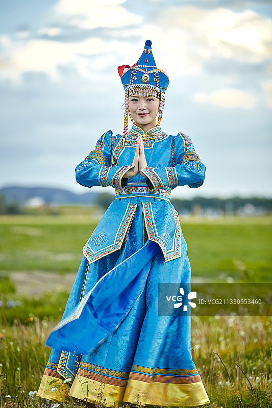草原上敖包前穿着蒙古族贵族服饰的少女图片素材
