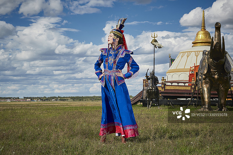 草原上蒙古战车前穿着蒙古族传统服饰的少女图片素材