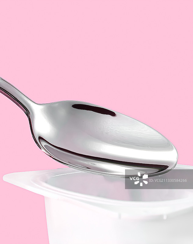 粉色背景下的勺子特写图片素材
