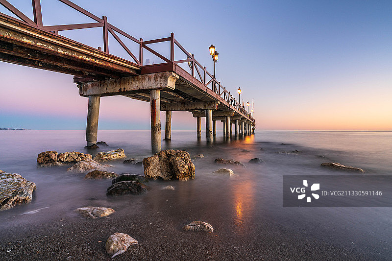 西班牙马贝拉日落时分的海上码头景色图片素材
