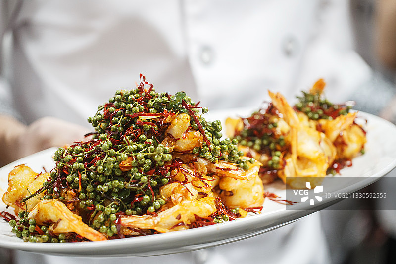 厨师刚刚做好的油炸藤椒麻辣开背虾图片素材