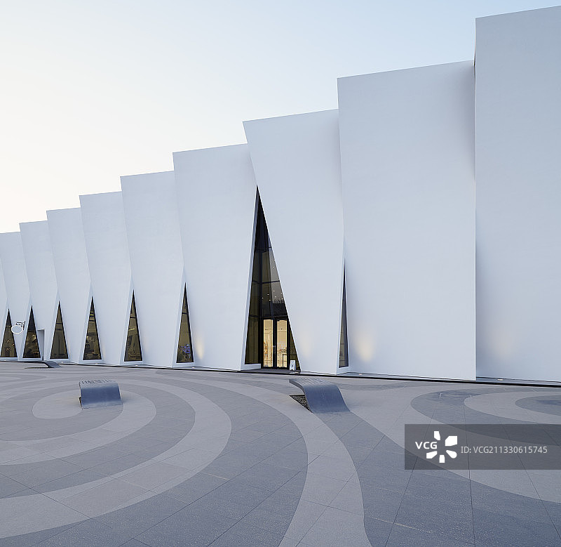 逆光下的美克洞学馆未来感建筑和门前广场图片素材