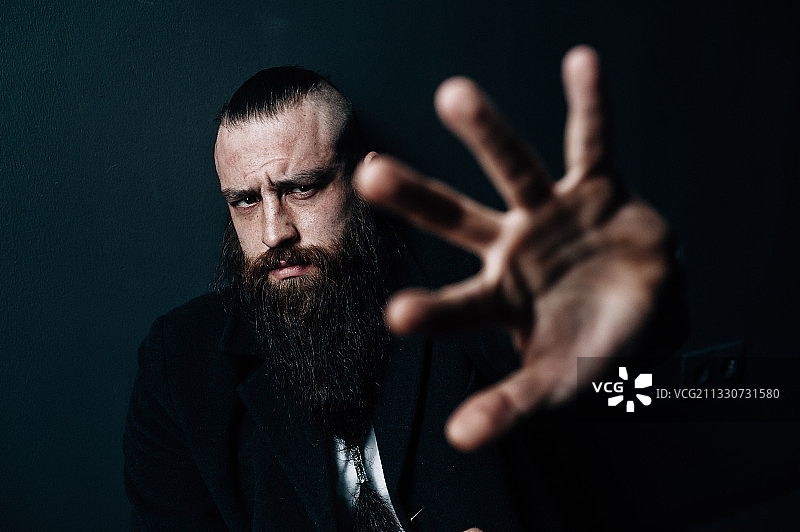 留着胡须的男人在黑色背景下手势的肖像，乌克兰图片素材