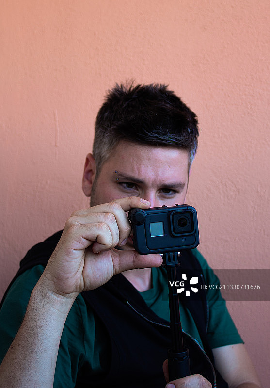 在西班牙，男人用相机对着墙拍照的画像图片素材
