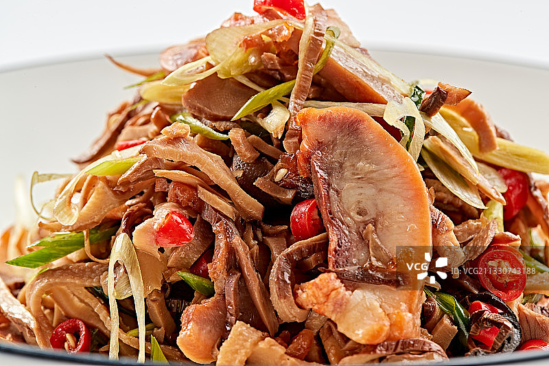 白色瓷盘装的香味小炒猪头肉图片素材