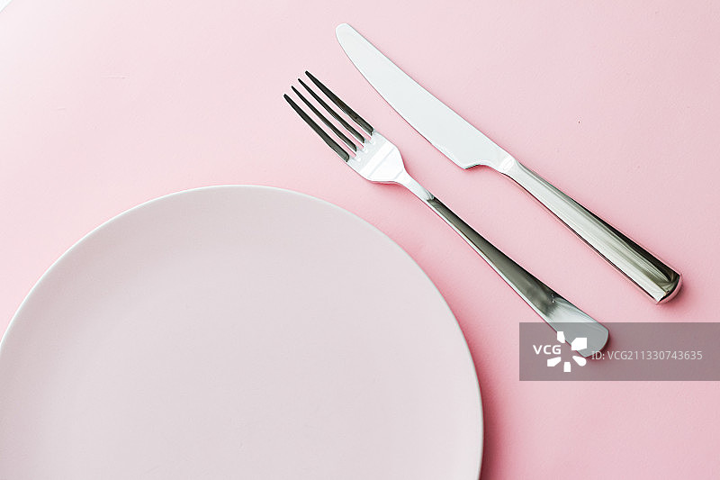 粉色背景上的空盘子和餐具模型，顶部图片素材