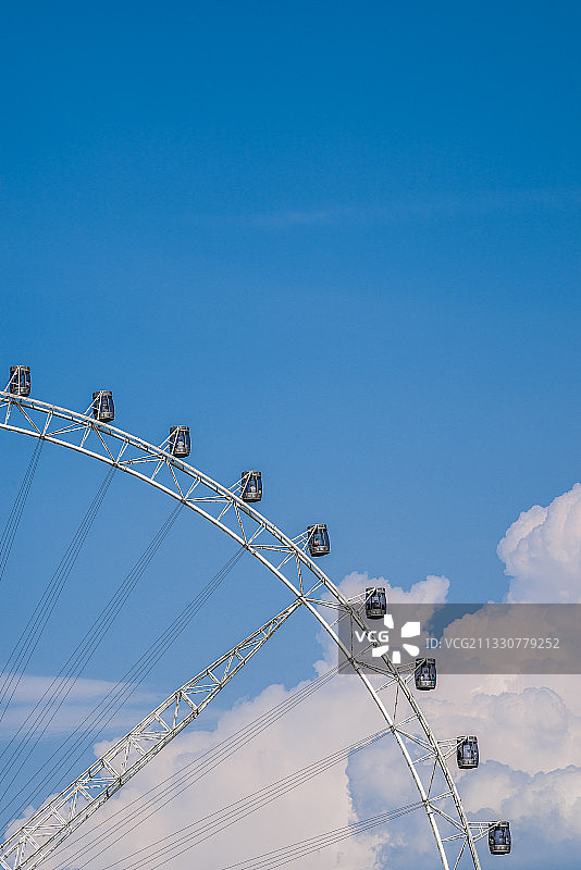 蓝天白云下游客在欢乐谷游乐场乘坐摩天轮图片素材