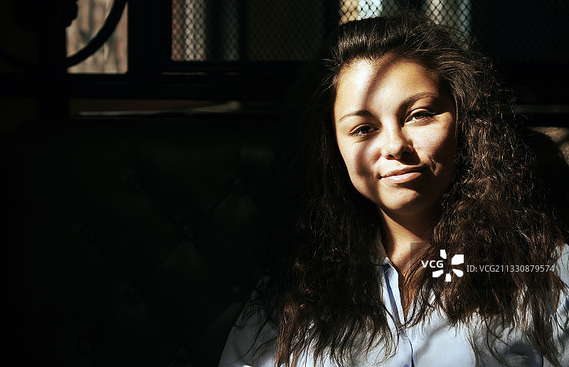 笑容满面的西班牙裔卷发女子肖像图片素材