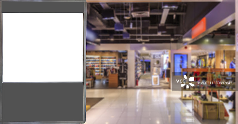 白色空白灯箱广告和模糊的商场店铺图片素材