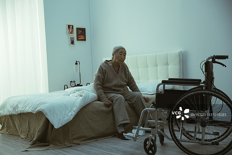 孤独的老人坐在床上图片素材
