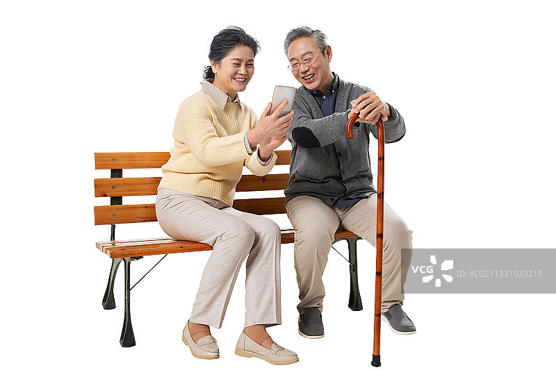 老年夫妇坐在长椅上看手机图片素材