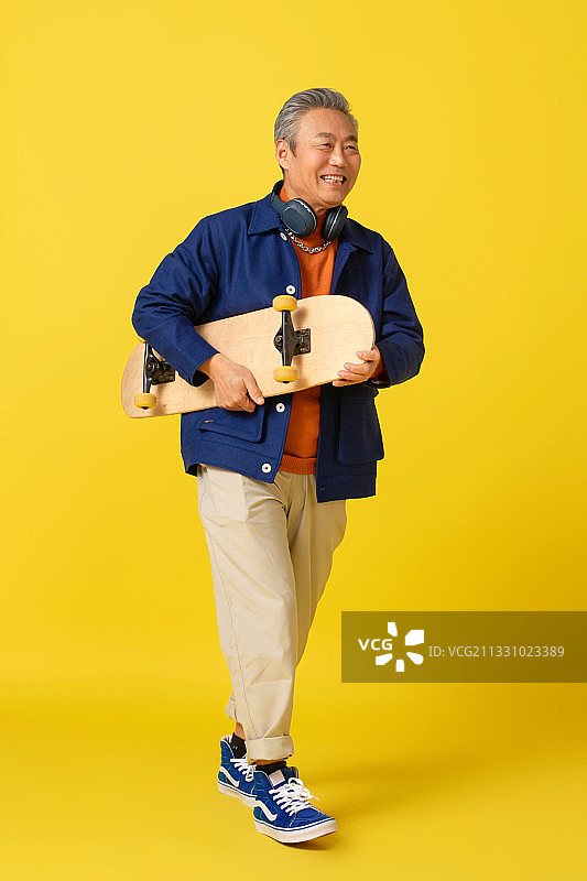 拿着滑板的快乐老人图片素材