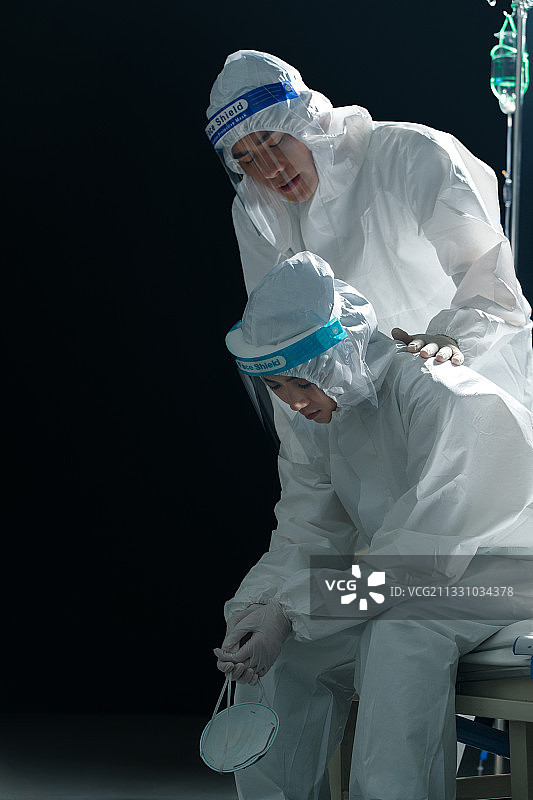 穿防护服的青年医生安慰同事图片素材
