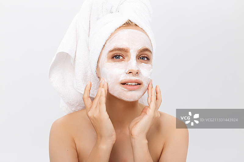 美丽女子在脸上涂抹保湿化妆霜特写图片素材