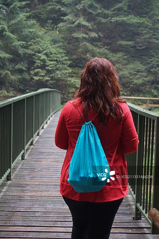 在人行天桥上行走的女子背影图片素材