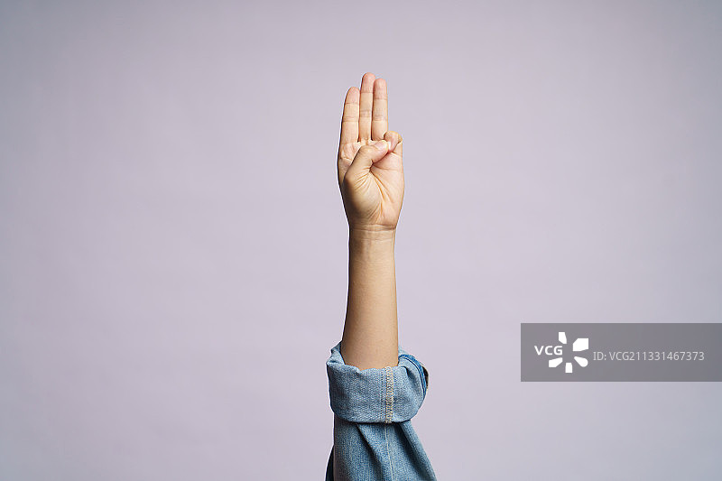 灰色背景下做手势的女人手部特写图片素材