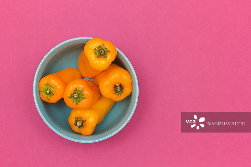 黄色背景下碗中橙子俯视图图片素材