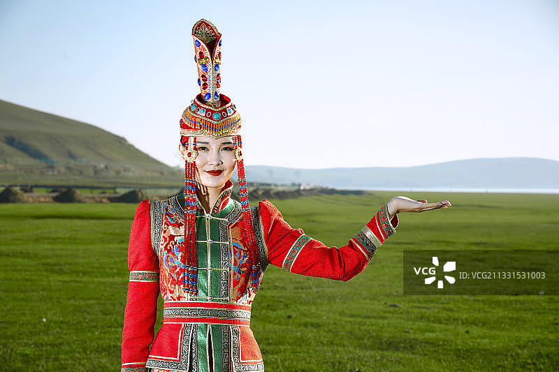 草原上穿着蒙古族传统服饰的亚洲年轻女性图片素材