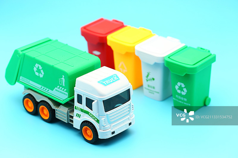 垃圾清运车和垃圾分类垃圾桶放在蓝色背景上图片素材