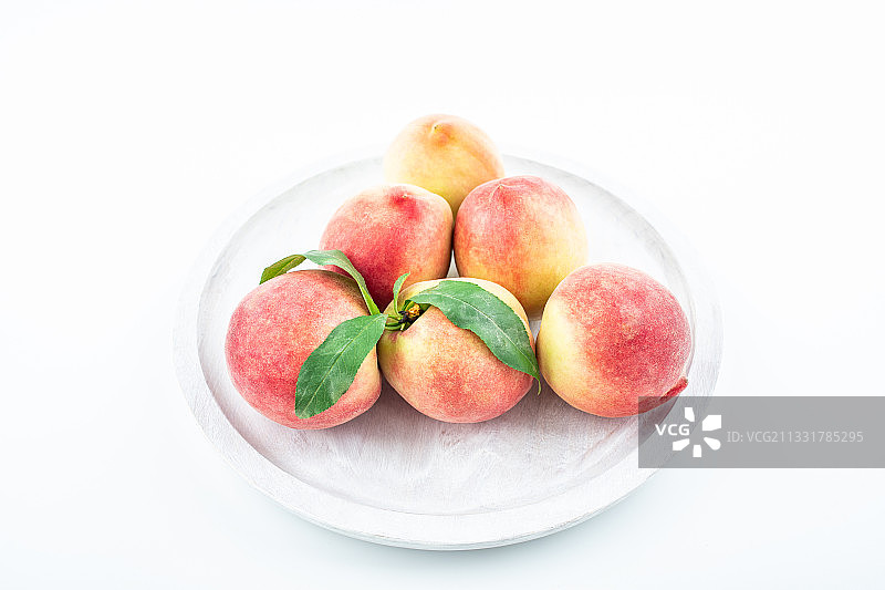 白背景上一盆新鲜桃子图片素材