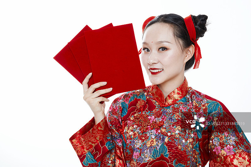 白色背景下穿着秀禾服手拿红包的亚洲少女图片素材