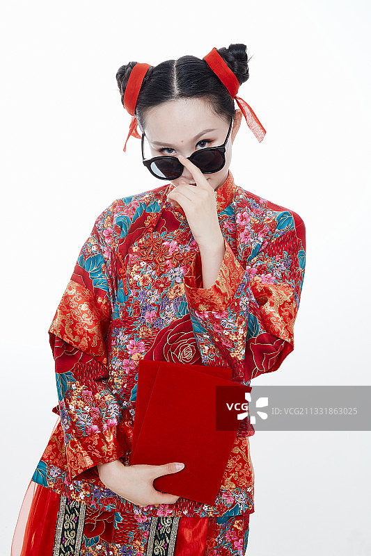 白色背景下穿着秀禾服手拿红包的亚洲少女图片素材