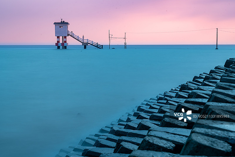 日出时分长江口的横沙岛水文站小屋孤零零地立在汹涌的大海里图片素材