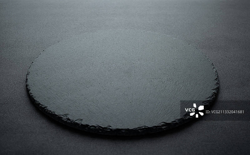 一个圆形黑色石板餐盘背景图片素材