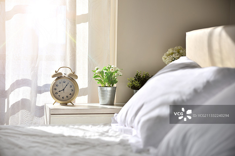 家中床头闹钟旁的床特写图片素材