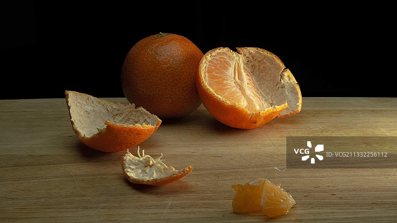 黑色背景下桌子上的橙子特写图片素材