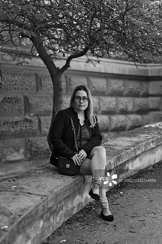 坐在挡土墙上的女人肖像，塞尔维亚斯雷姆斯基卡尔洛夫奇图片素材