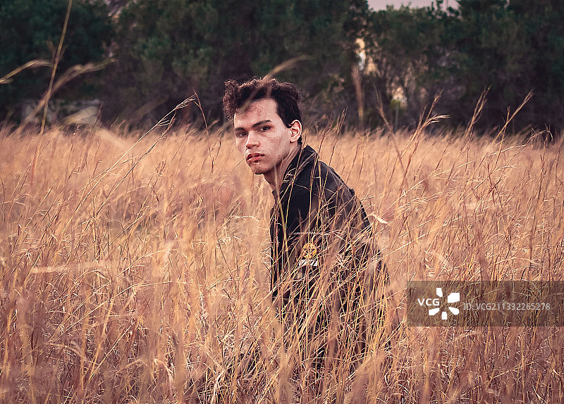 站在草地上的年轻男子肖像图片素材