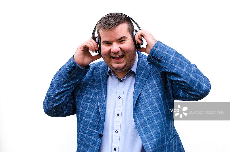 男子靠在白色背景前听音乐图片素材