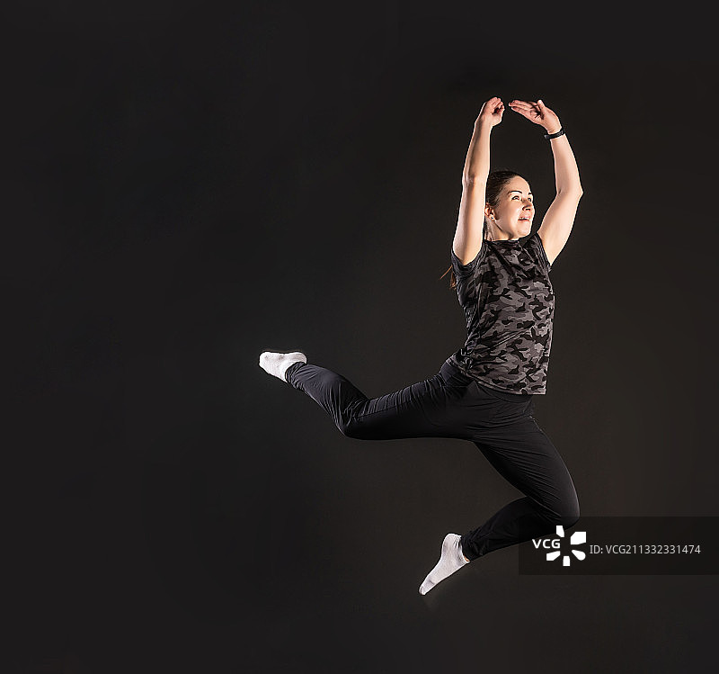 年轻男人在黑色背景下跳跃图片素材