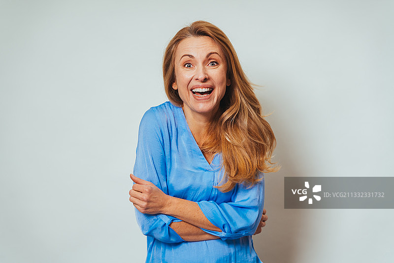 站在白色背景前微笑的年轻女子肖像图片素材