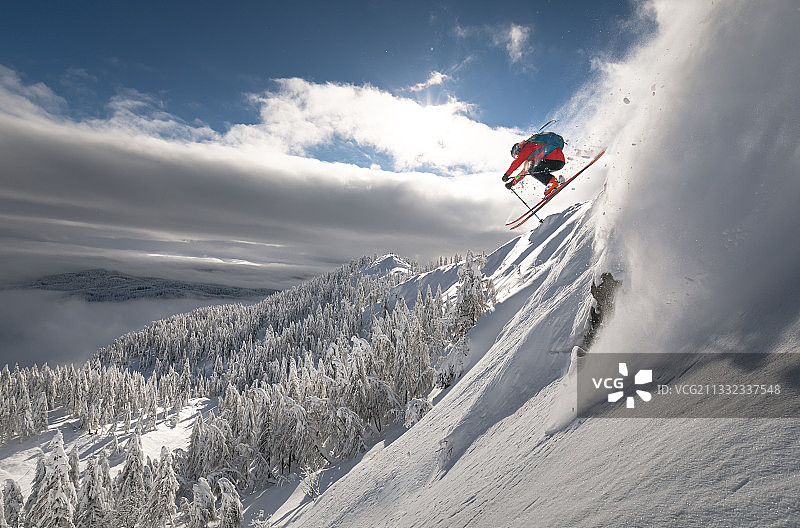 男子在雪山上滑雪，背景是天空，地点：斯洛文尼亚Pokljuka图片素材