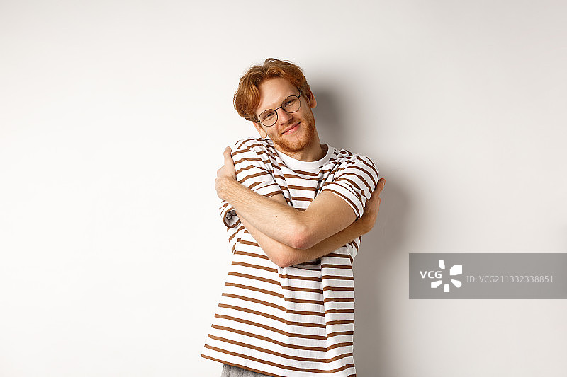微笑的男人的肖像双臂交叉站在白色的背景图片素材