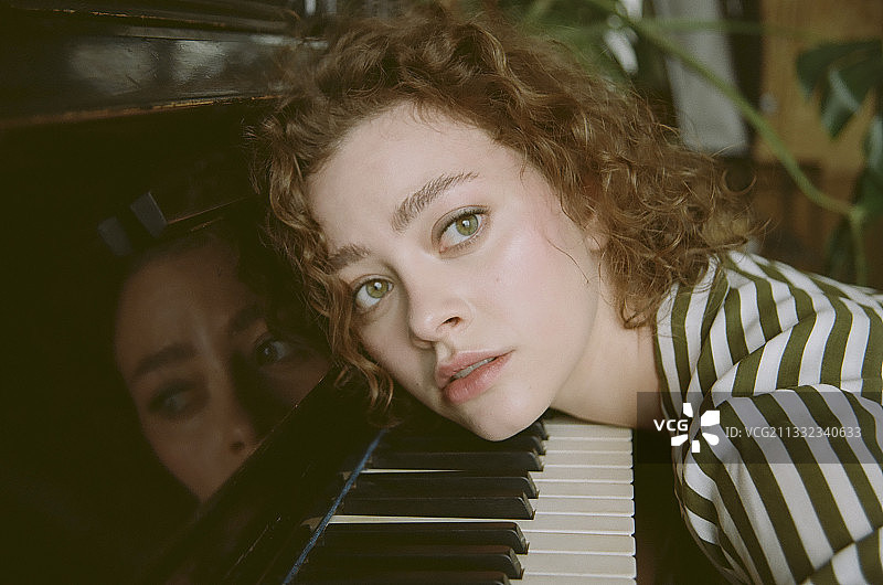 在钢琴旁的年轻女子画像，俄罗斯图片素材