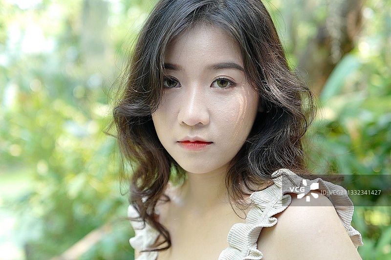 植物背景前的年轻女子肖像图片素材