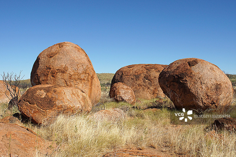 清澈蓝天下田野上的岩层景观图片素材