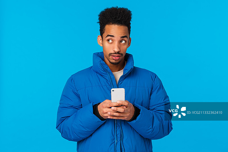 蓝色背景下男人使用手机肖像图片素材