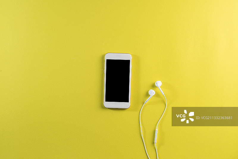 黄色背景上的智能手机俯视图图片素材
