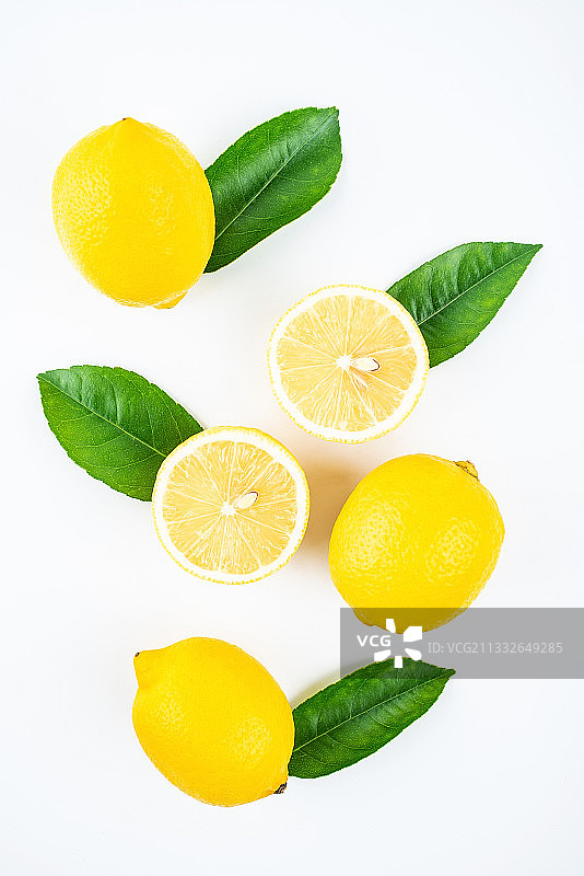 白背景上的新鲜带叶子的柠檬切片图片素材