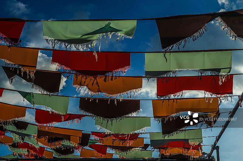 天空下悬挂的彩色旗帜低角度视角图片素材