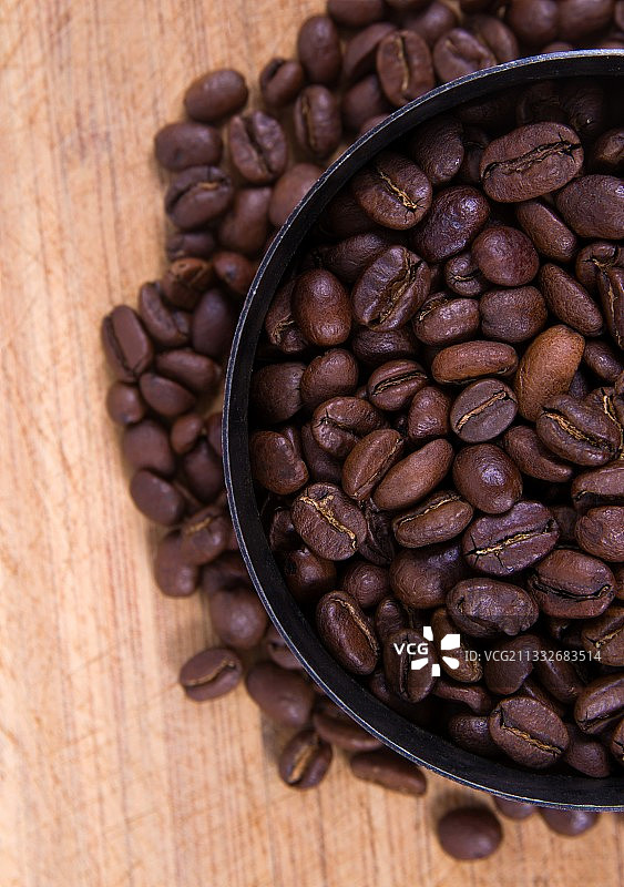 木桌上碗中烘焙咖啡豆的俯视照片图片素材