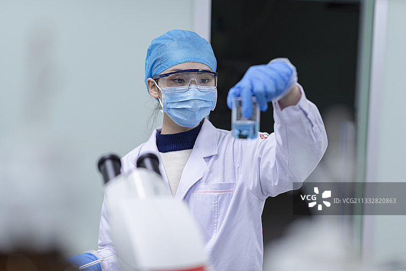化验室里操作试验的年轻女医务人员图片素材
