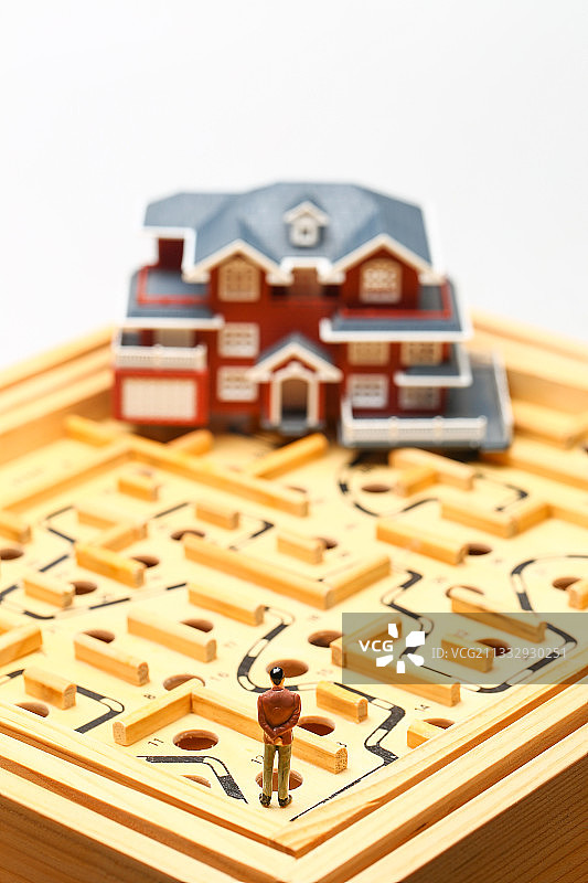 男人站在迷宫和别墅房屋模型前图片素材